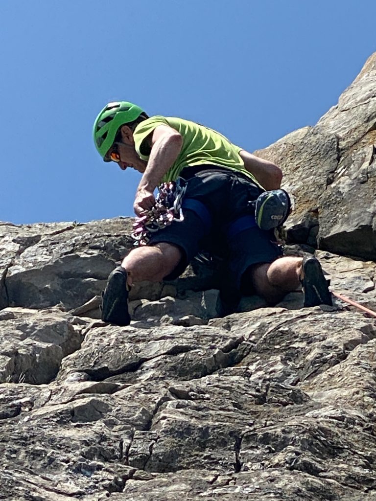 Jurassic Climbing Student looking for a suitable gear placement on a rock climb
